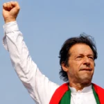 Former Prime Minister Imran Khan raises his fist during a PTI public gathering.