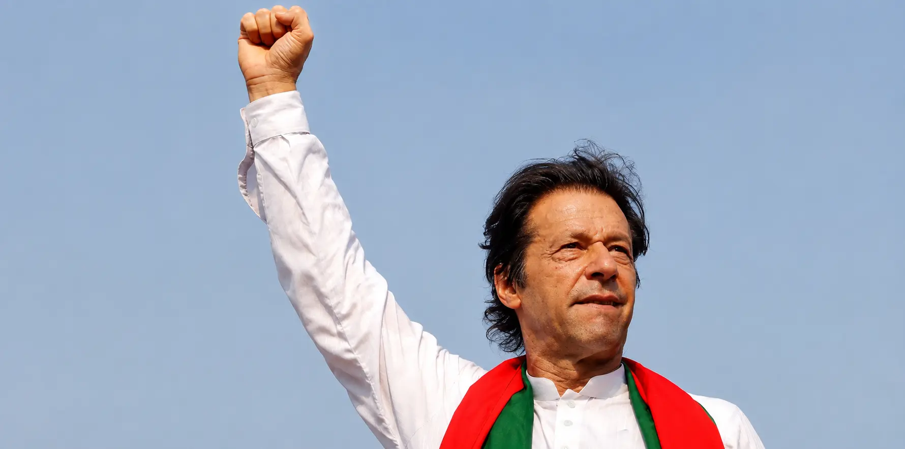 Former Prime Minister Imran Khan raises his fist during a PTI public gathering.